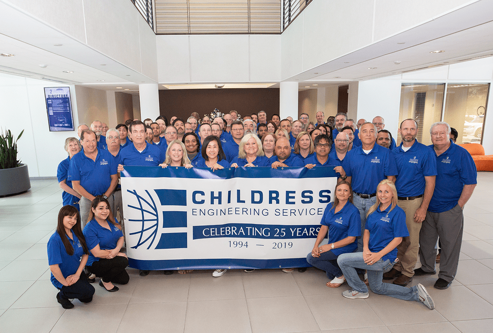 A large group of employees in blue shirts pose indoors, holding a banner that reads, "Childress Engineering Services, Celebrating 25 Years, 1994–2019," highlighting their legacy in structural engineering and expert consulting.