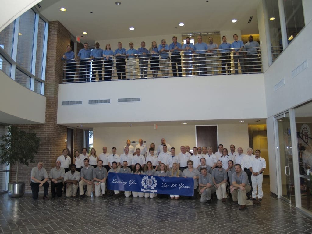 Childress Engineering team at Texas office with a banner celebrating 15 years