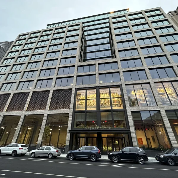 A modern multi-story office building with large glass windows, offering expert consulting in structural engineering, and several parked cars in front, seen from street level at 125 Greenwich Street.