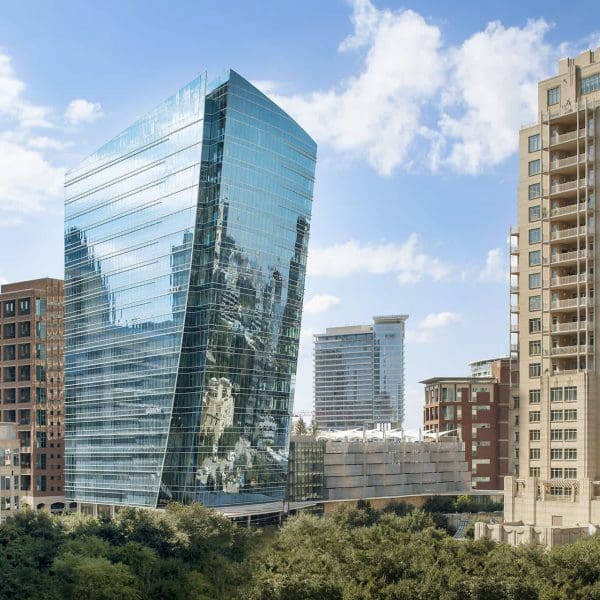 Angle view of the McKinney & Olive Tower, showcasing the dramatic outward-sloping glass facade and complex geometry engineered by Childress Engineering