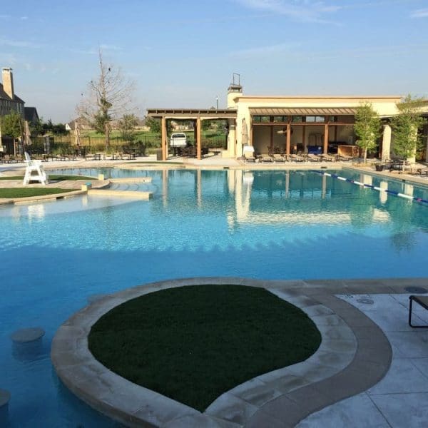 Spacious Lexington Amenity Center outdoor swimming pool with shaded pavilion, and landscaped grassy areas, showcasing thoughtful CES architecture design